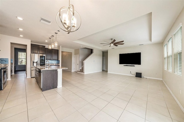 kitchen with visible vents, a tray ceiling, open floor plan, and dark brown cabinets