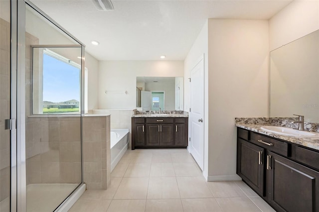 bathroom featuring tile patterned floors, two vanities, a sink, a shower stall, and a bath