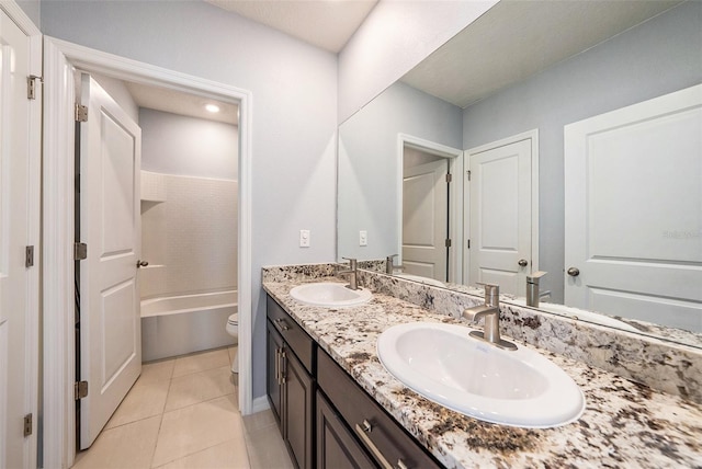 full bathroom featuring double vanity, toilet, a sink, and tile patterned floors