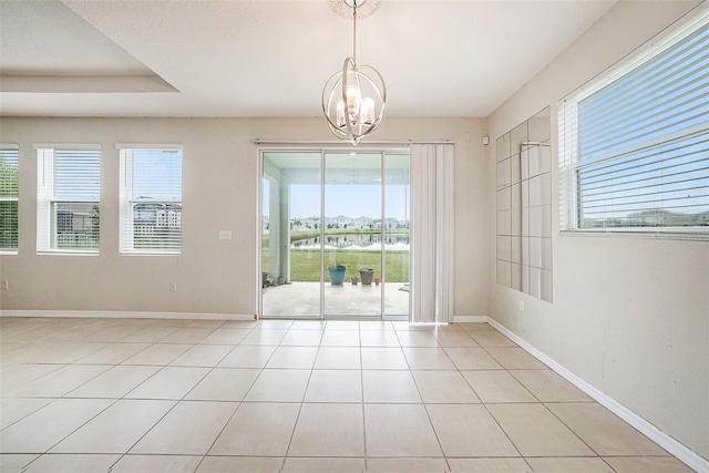 unfurnished dining area featuring baseboards, an inviting chandelier, and light tile patterned floors
