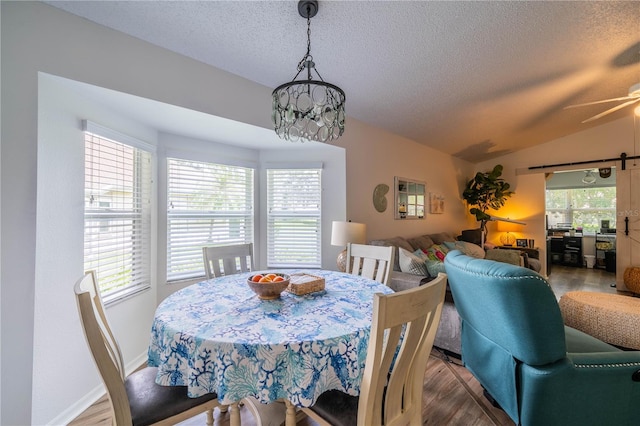 dining room with ceiling fan, a textured ceiling, hardwood / wood-style floors, and lofted ceiling