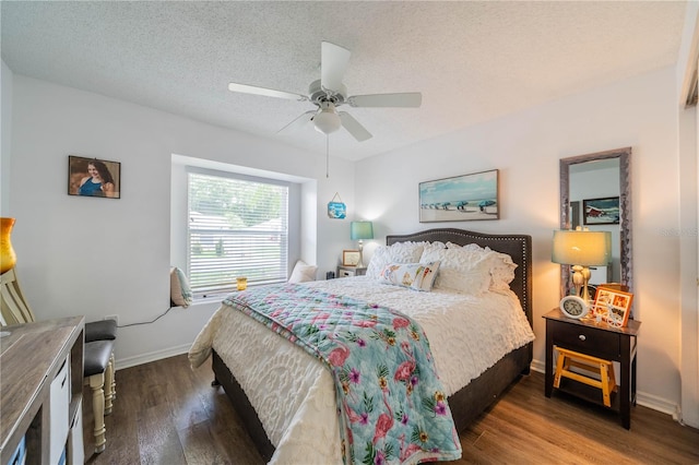 bedroom with ceiling fan, dark hardwood / wood-style flooring, and a textured ceiling