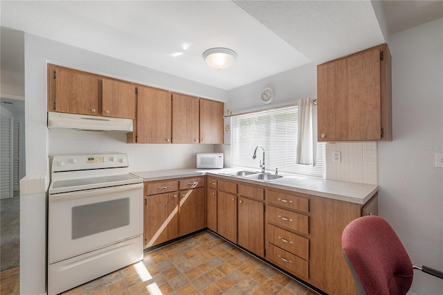 kitchen featuring sink, backsplash, and white appliances