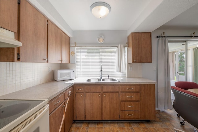 kitchen featuring sink, backsplash, and white appliances