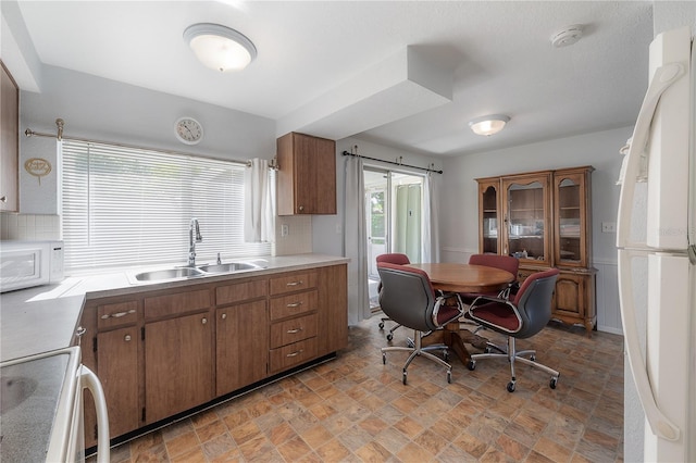 kitchen with white appliances, sink, and decorative backsplash