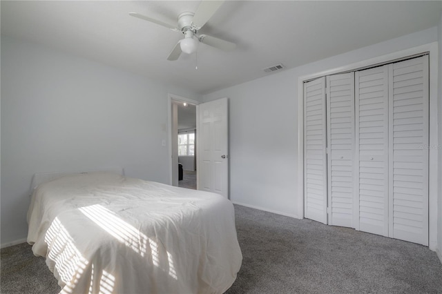 bedroom with a closet, ceiling fan, and dark colored carpet