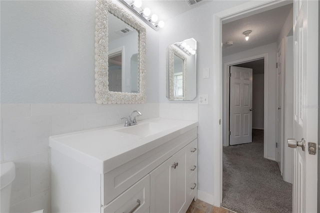 bathroom featuring vanity and tile walls