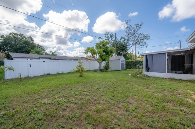 view of yard with a storage shed and a sunroom