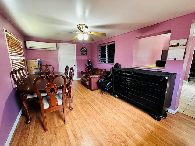 dining room featuring an AC wall unit, light wood-type flooring, and ceiling fan