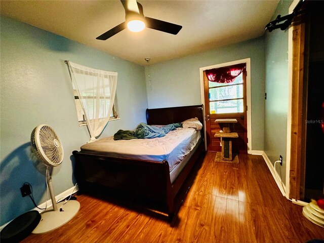 bedroom with hardwood / wood-style flooring, vaulted ceiling, and ceiling fan