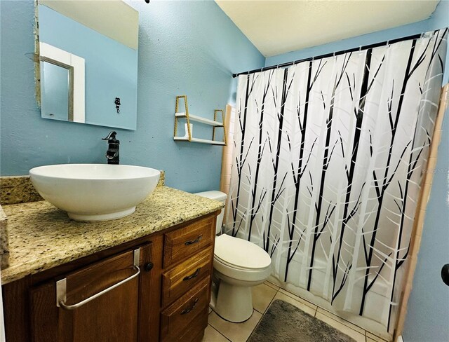 full bathroom with shower / bathtub combination with curtain, vanity, toilet, and tile patterned floors