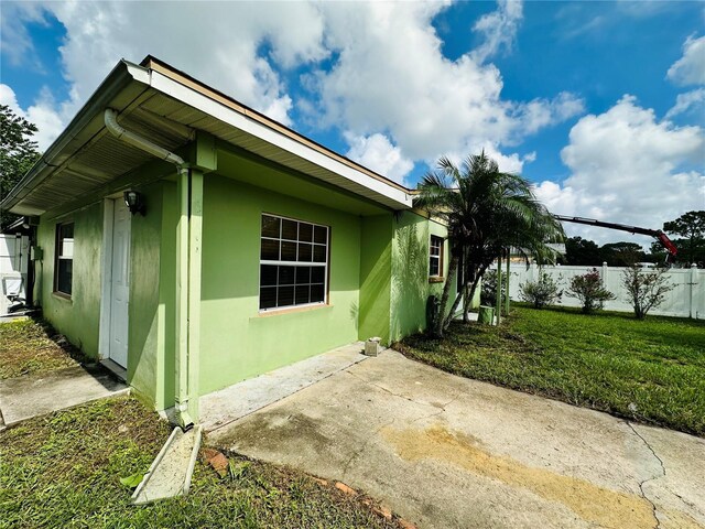 view of property exterior featuring a patio area and a lawn