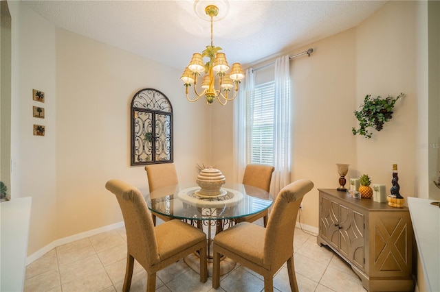 dining area featuring light tile patterned floors, a textured ceiling, baseboards, and a notable chandelier