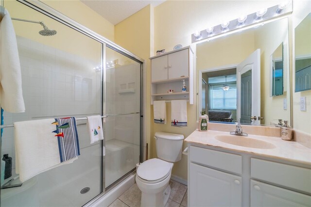 bathroom featuring tile patterned floors, vanity, a shower with door, and toilet