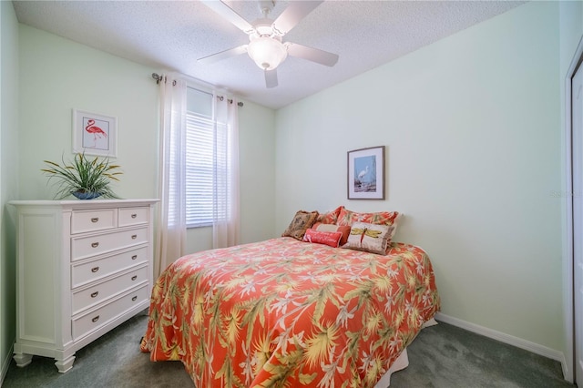 bedroom with a ceiling fan, baseboards, dark colored carpet, and a textured ceiling