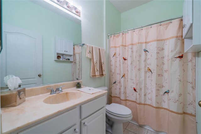 bathroom with toilet, tile patterned floors, and vanity