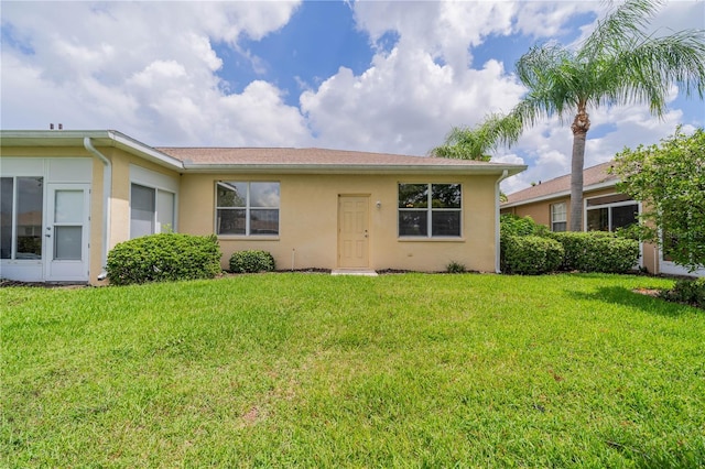 view of front of property featuring a front lawn and stucco siding