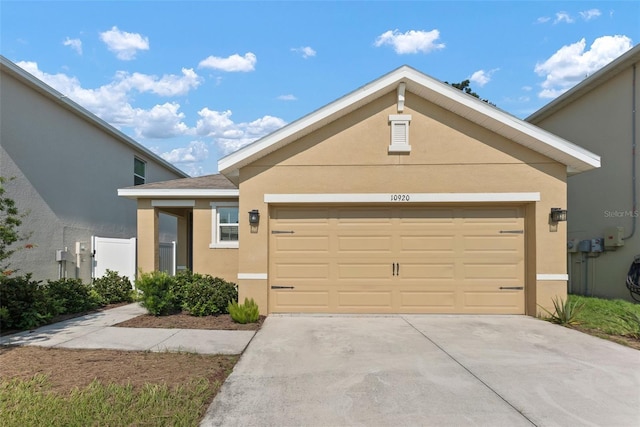 view of front of house featuring an attached garage, concrete driveway, and stucco siding