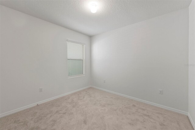 carpeted empty room with a textured ceiling