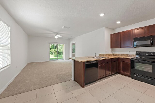 kitchen with black appliances, light tile patterned flooring, ceiling fan, sink, and kitchen peninsula