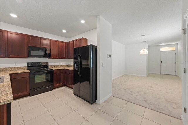 kitchen featuring black appliances, light stone countertops, light carpet, and decorative light fixtures