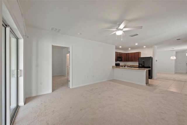 unfurnished living room featuring ceiling fan and light carpet