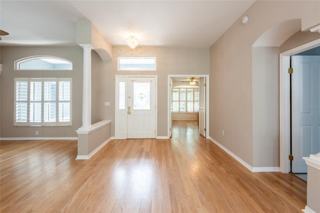 entryway featuring decorative columns, ceiling fan, and light wood-type flooring