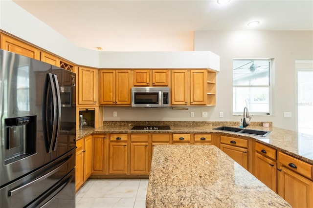 kitchen featuring light stone countertops, stainless steel appliances, and sink