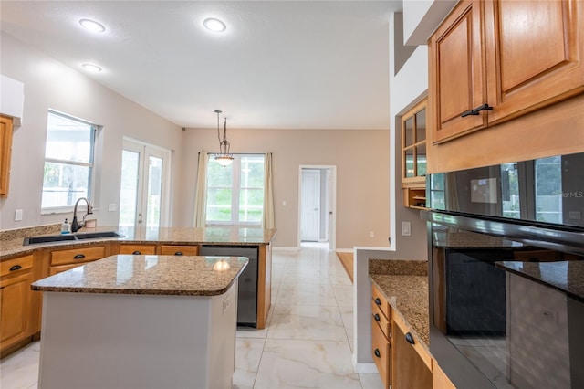 kitchen with sink, hanging light fixtures, stainless steel dishwasher, light stone countertops, and a kitchen island