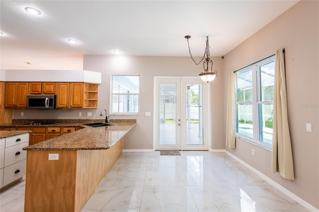 kitchen with french doors, sink, dark stone countertops, decorative light fixtures, and kitchen peninsula