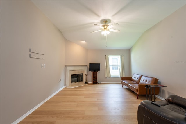 living room featuring ceiling fan, light hardwood / wood-style flooring, and lofted ceiling