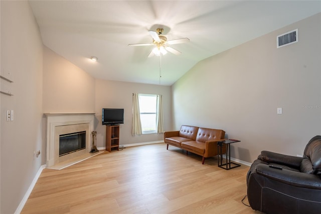 living room featuring ceiling fan, light hardwood / wood-style floors, and lofted ceiling