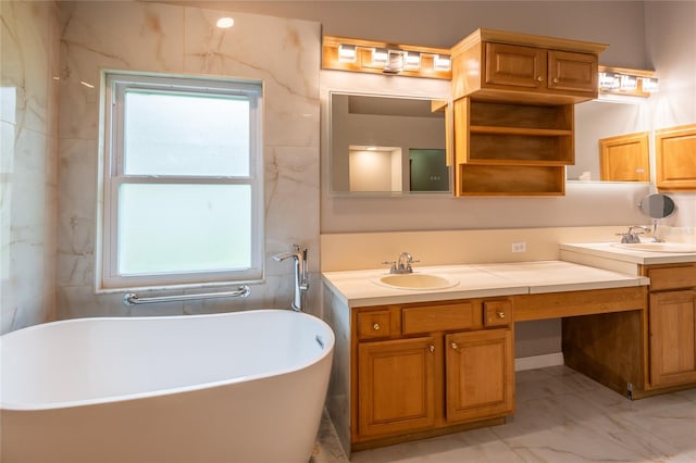 bathroom with a tub to relax in, vanity, and a healthy amount of sunlight