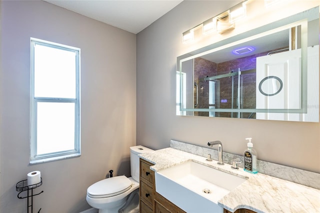 bathroom featuring vanity, an enclosed shower, and toilet