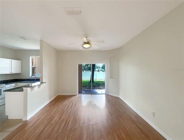 interior space featuring ceiling fan, sink, and light hardwood / wood-style floors