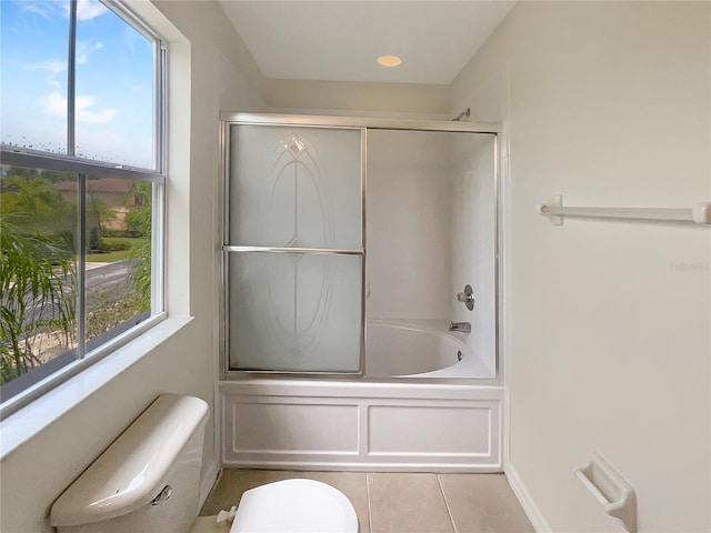 bathroom featuring toilet, tile patterned flooring, and bath / shower combo with glass door