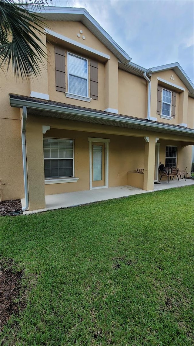 rear view of house with a lawn and a patio area