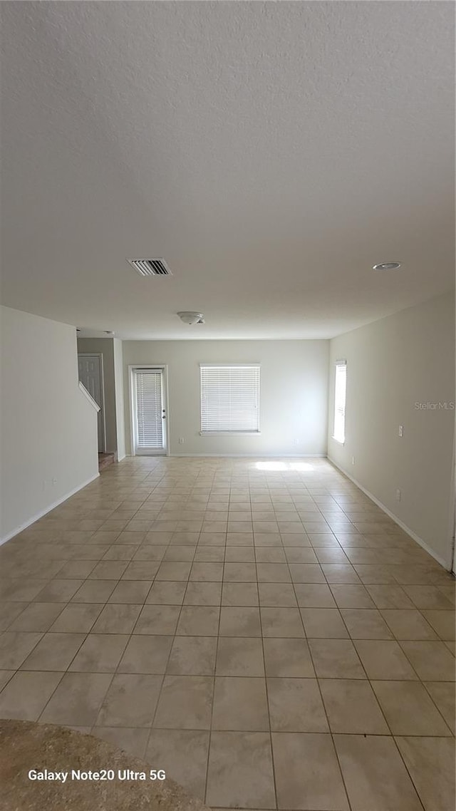 empty room featuring light tile patterned floors and a textured ceiling