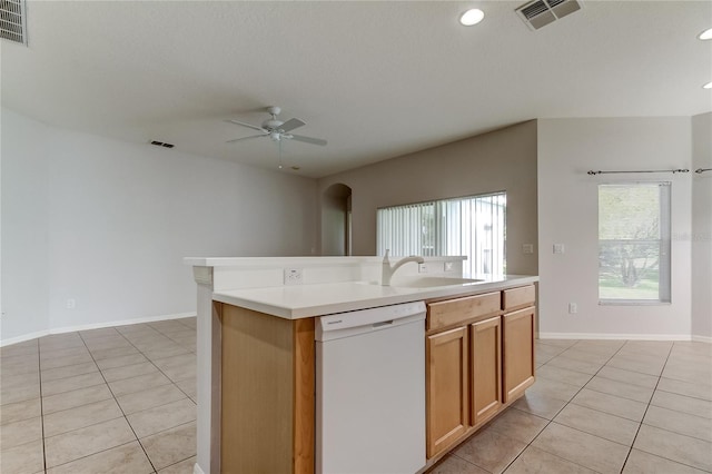 kitchen with light tile patterned flooring, an island with sink, white dishwasher, ceiling fan, and sink