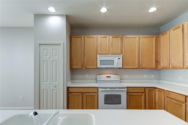 kitchen with sink, light brown cabinets, and white appliances