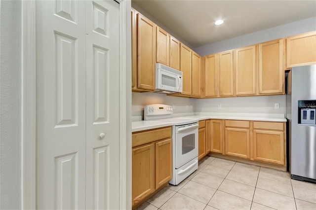 kitchen with light tile patterned flooring, white appliances, and light brown cabinetry