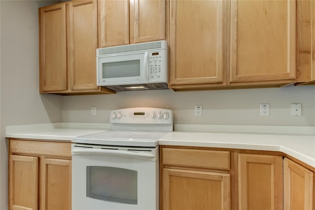 kitchen featuring white appliances and light brown cabinets