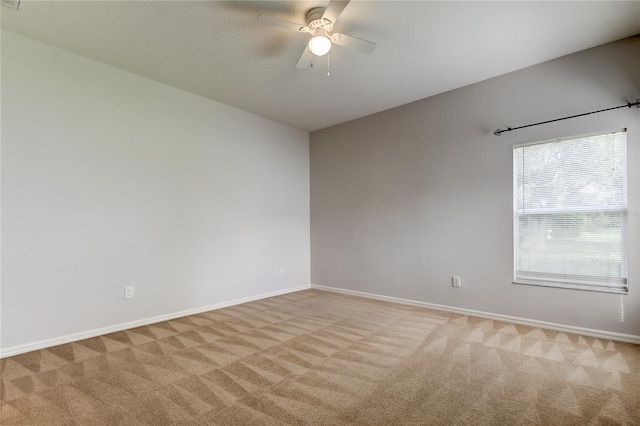 carpeted empty room featuring ceiling fan and plenty of natural light