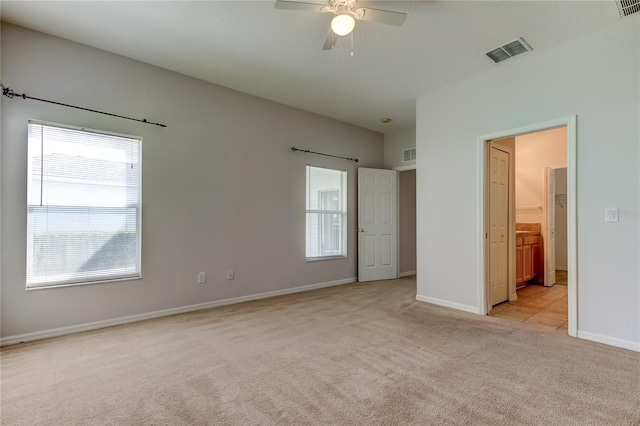 unfurnished bedroom featuring ceiling fan, connected bathroom, and light colored carpet