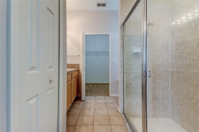 bathroom with tile patterned floors, vanity, and walk in shower