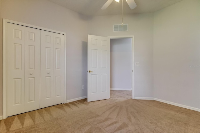 unfurnished bedroom with ceiling fan, a closet, and light colored carpet