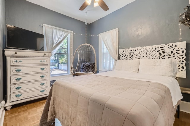 bedroom with ceiling fan and parquet flooring