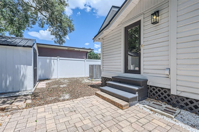 view of patio / terrace featuring central air condition unit and a storage shed