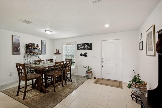 tiled dining room with a textured ceiling