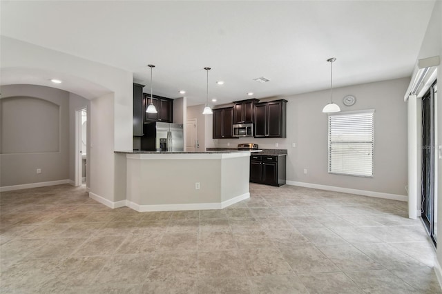 kitchen with stone counters, kitchen peninsula, dark brown cabinets, light tile patterned floors, and stainless steel appliances